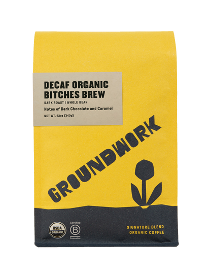 A yellow and brown bag of Groundwork Coffees Decaf Bitches Brew, a dark roast whole bean coffee with rich chocolate and caramel notes.