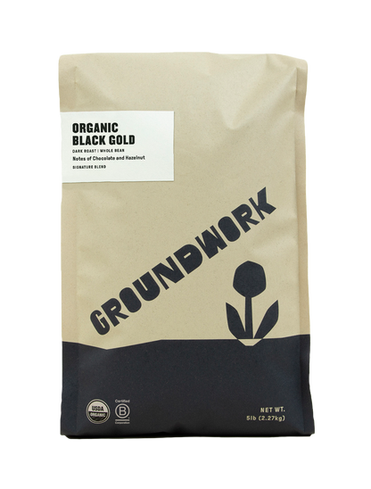 A 5 lb bag of Groundwork Coffee Co Black Gold whole bean coffee, featuring bold chocolate and hazelnut notes and a black flower design.