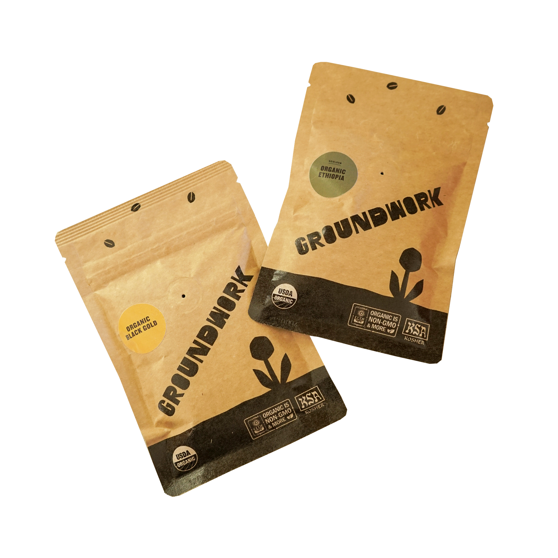 Two small, kraft paper 2oz sample coffee pouches from Groundwork Organic Coffee Roasters displayed on a white background. 
One pouch is labeled “Organic Black Gold” with a small, yellow sticker, and the other is labeled “Organic Ethiopia” with a small, green sticker. 
Both bags feature the Groundwork logo, USDA Organic and KSA Kosher certifications, and a black flower graphic at the bottom.